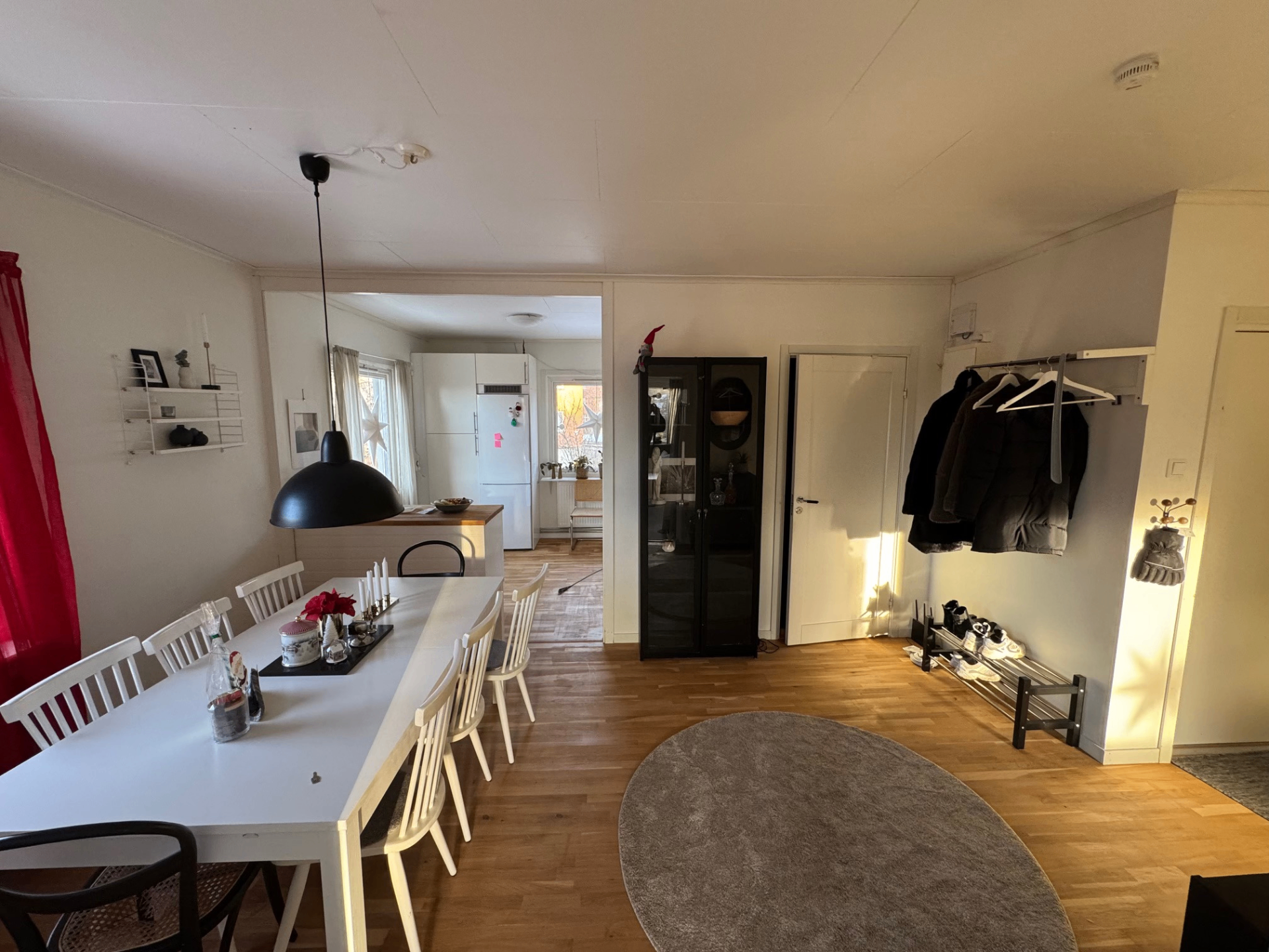 Ljust vardagsrum med matbord och trägolv